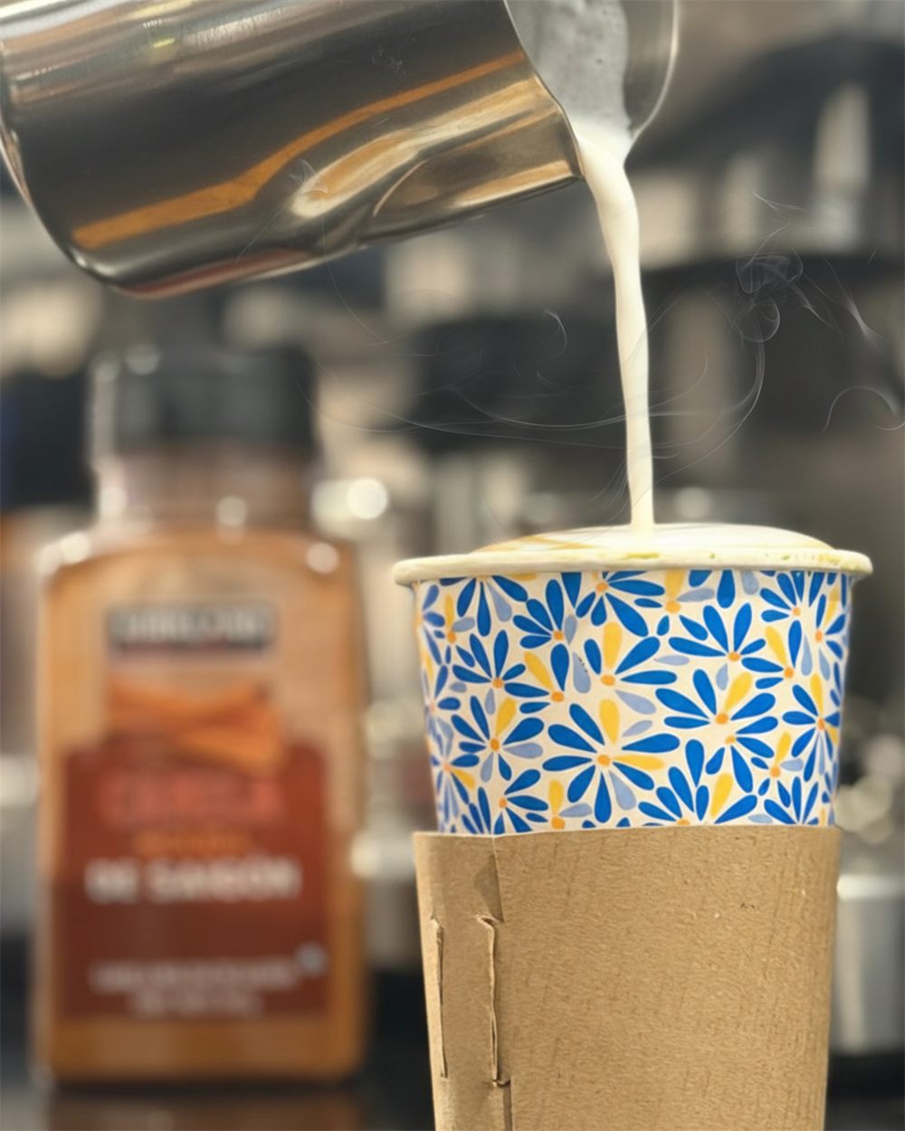 Barista de Pachucrepas vertiendo leche vaporizada en un vaso de café para llevar